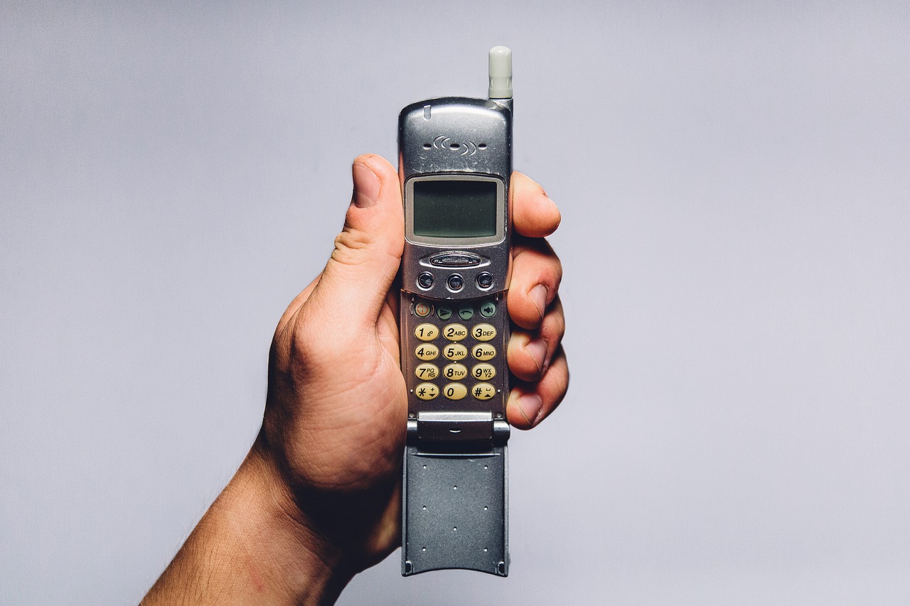 Cellulari anni 2000, modelli iconici e ricercati dai collezionisti, esposti su uno sfondo nostalgico.